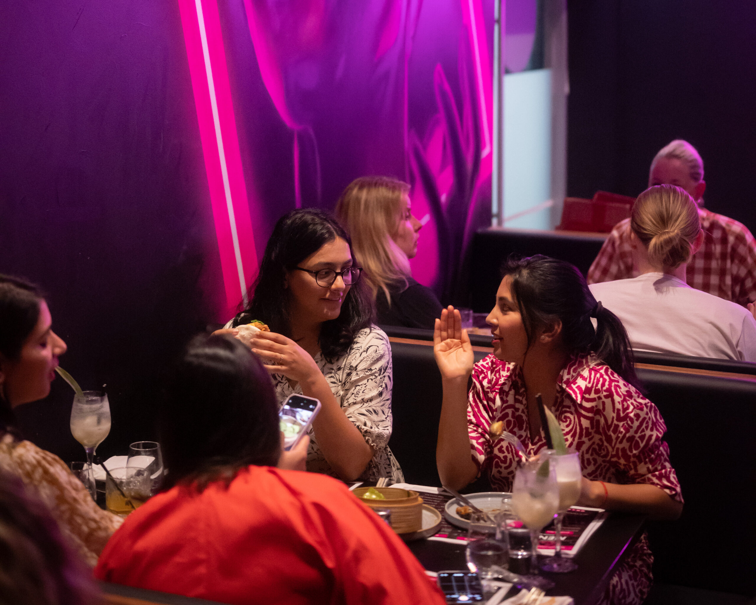 Group enjoying a perfect night out with cocktails and food at Mr. Wabi